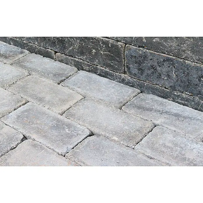 Christoph Pflasterstein CHR-Collo - 24 x 12 x 7,1 cm, Beton, Anthrazit - Nahaufnahme von grauen Pflastersteinen, die im Fischgrätenmuster verlegt sind und eine robuste und stilvolle Oberfläche bilden.
