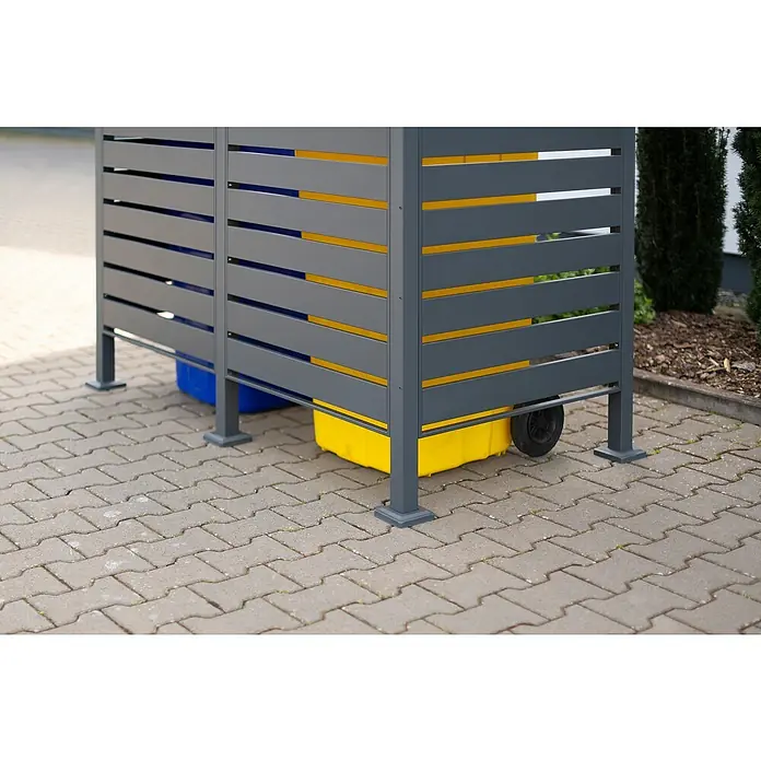 Westmann Mülltonnenbox Verkleidung Planum - 90 x 170 x 150 cm, Anthrazit - Das Bild zeigt eine graue Mülltonnenbox mit gelben und blauen Mülltonnen darin, die auf einem gepflasterten Bereich steht.