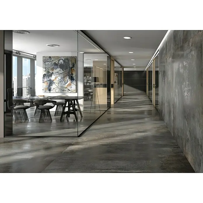 BHS Showroom Revestimiento de pared Iron slim - 80 x 160 cm, Oxido, Satinado, Rectificado - Interior de oficina con mesa de conferencias y sillas detrás de una pared de vidrio, combinado con un pasillo con suelo y pared de hormigón.