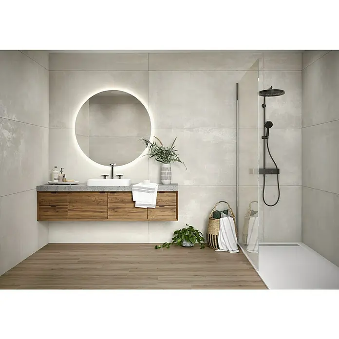 BHS Showroom Revestimiento de pared Marais - 80 x 160 cm, Gris, Brillante, Rectificado - Moderno baño con mueble de madera, espejo redondo iluminado y ducha a ras de suelo con sistema de ducha en negro.