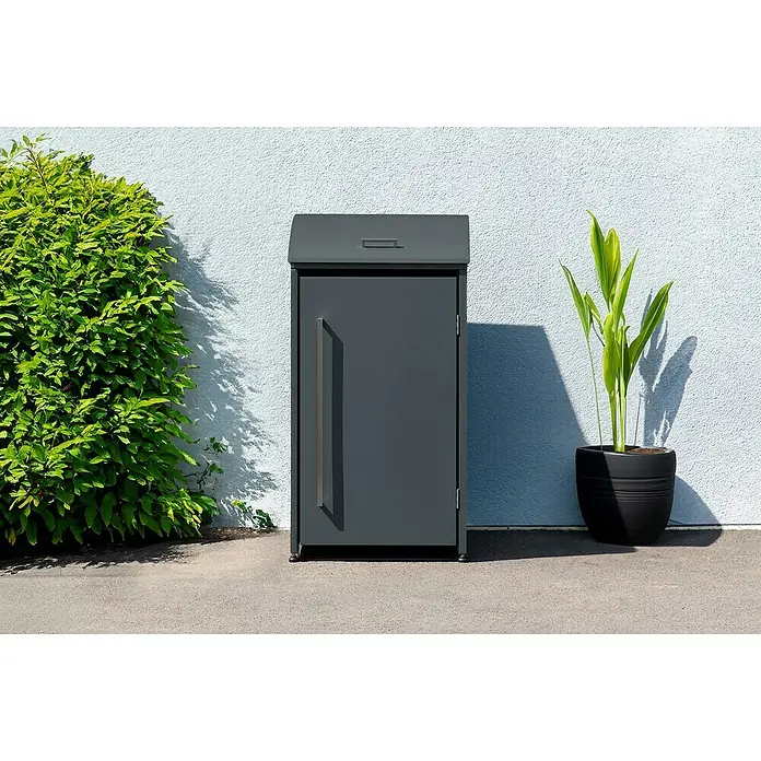 Westmann Mülltonnenbox Moderna - Stahl, Anthrazit, Geeignet für Anzahl Mülltonnen: 1 Stk. - Der graue Paketkasten mit Griff neben einer grünen Pflanze und einem Topf. Ideal für sichere Lieferungen.