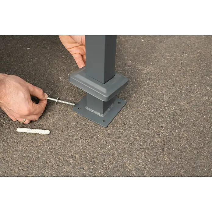 Westmann Mülltonnenbox Verkleidung Planum - 90 x 410 x 150 cm, Anthrazit - Eine graue Pfostenstütze wird mit einer Schraube und einem Dübel auf einer grauen Oberfläche befestigt.