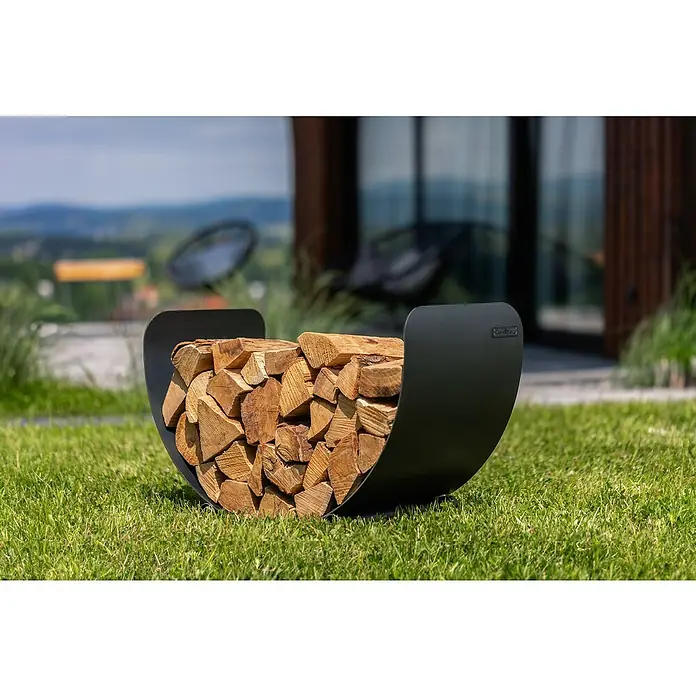 Kaminholzregal Turyn - 70 x 36 x 45 cm, Stahl, Schwarz - Brennholz in einem modernen, halbmondförmigen, mattschwarzen Holzkorb auf Rasen. Holzkorb für den Aussenbereich zur Aufbewahrung von Kaminholz.