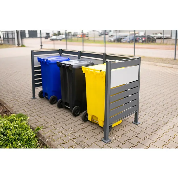 Westmann Mülltonnenbox Verkleidung Planum - 90 x 250 x 120 cm, Anthrazit/Grau - Bild einer Mülltonnenbox mit drei Mülltonnen in blau, schwarz und gelb. Der Mülltonnenständer ist aus grauem Metall gefertigt und steht auf Pflastersteinen.