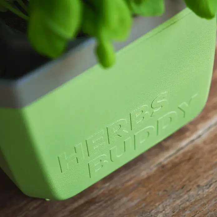 Gusta Garden Kräutertopf Herbs Buddy - Kunststoff, Dunkelgrün, 1 Stk. - Nahaufnahme eines Kräutertopfes "Herbs Buddy" in hellem Grün auf einem Holztisch, der sich ideal für den Anbau frischer Kräuter eignet.