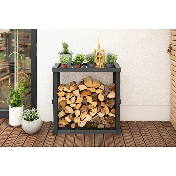 Westmann Kaminholzregal Harald - 108 x 52 x 106 cm, Holz, Anthrazit - Ein mit Holz gefülltes, graues Holzregal im Freien, dekoriert mit Pflanzen auf der Oberseite, bietet sowohl Funktionalität als auch dekoratives Flair.