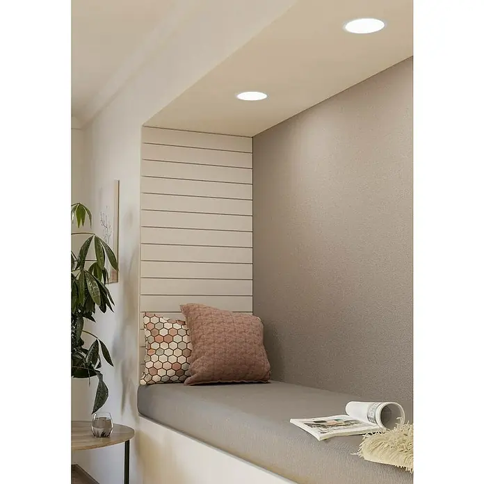 Eglo Fueva 5 LED-Einbauspot - 10,5 W, Warmweiß, Weiß, Ø x H: 16,6 x 2,6 cm, Dimmbar - Ein gemütlicher Lesebereich mit stilvollem Kissen und guter Beleuchtung, ideal zum Entspannen mit einem Buch in ruhiger Atmosphäre.