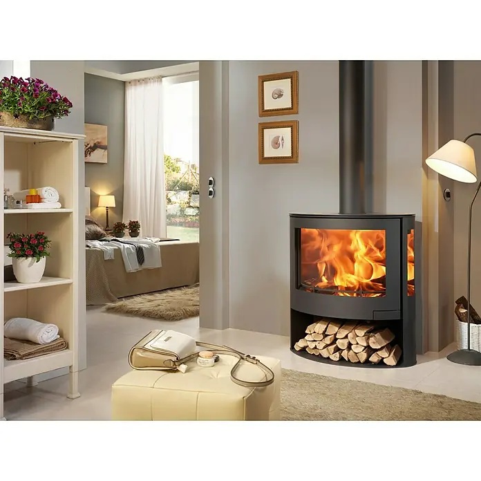 Panadero Kaminofen Iris Eco - 7,8 kW, Raumheizvermögen: 240 m³, Material Verkleidung: Stahl, Schwarz - Ein modernes, schwarzes Kaminofen-Design mit Holzscheitlagerung und lebendigem Flammenspiel im Wohnraum für Wärme und Atmosphäre.