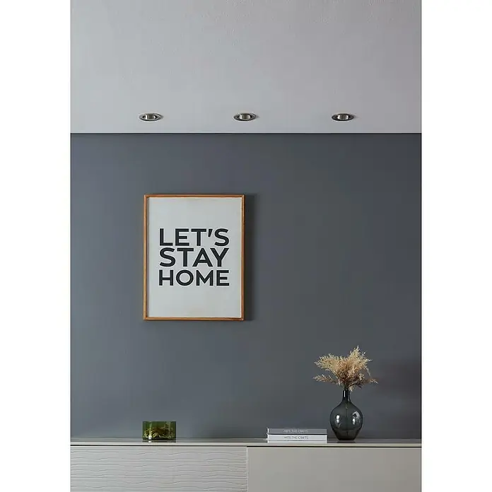 Eglo LED-Einbauleuchte SALICETO - Warmweiß, Durchmesser: 8,8 cm, Nickel-matt, 3 Stk. - Ein stilvolles Interieur mit einem gerahmten "Let's Stay Home"-Poster, einer eleganten Vase mit Trockenblumen und dezenten Dekorationsgegenständen auf einem Sideboard.