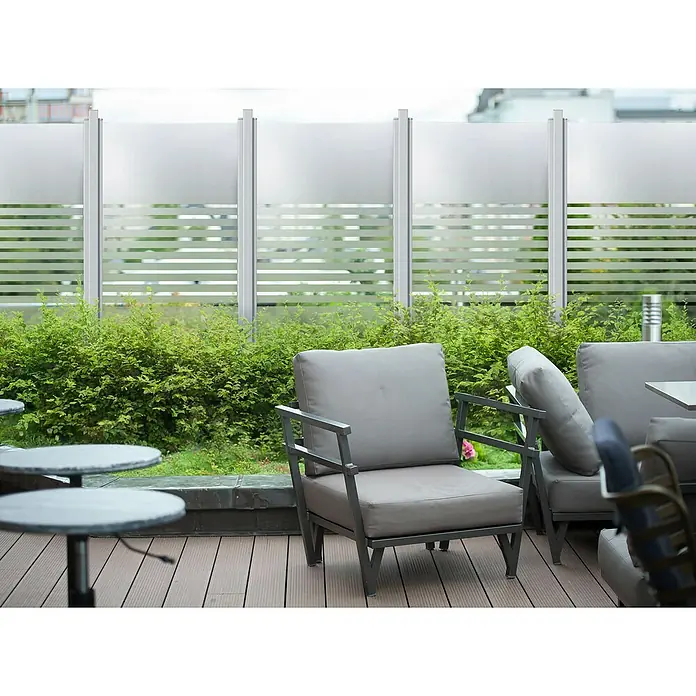GroJa Ambiente Sichtschutzelement Streifen - B x H: 90 x 180 cm - Außenbereich mit grauen Terrassenstühlen, dunklen Metallrahmen, runden Tischen und einem gestreiften Sichtschutz auf Holzterrasse.