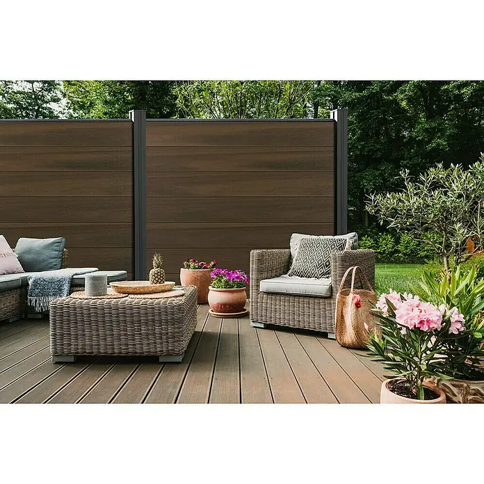 GroJa Solid Steckzaun Grande - 180 x 180 cm, Walnuss - Dunkelbrauner Verbundstoff-Sichtschutz, der einen Terrassenbereich mit Sitzgelegenheiten abgrenzt.