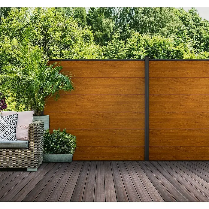 GroJa BasicLine Steckzaun - 180 x 30 cm, Golden Oak - Gartenterrasse mit dunkelbraunen WPC-Dielen und einem hellbraunen WPC-Sichtschutzzaun in Holzoptik.