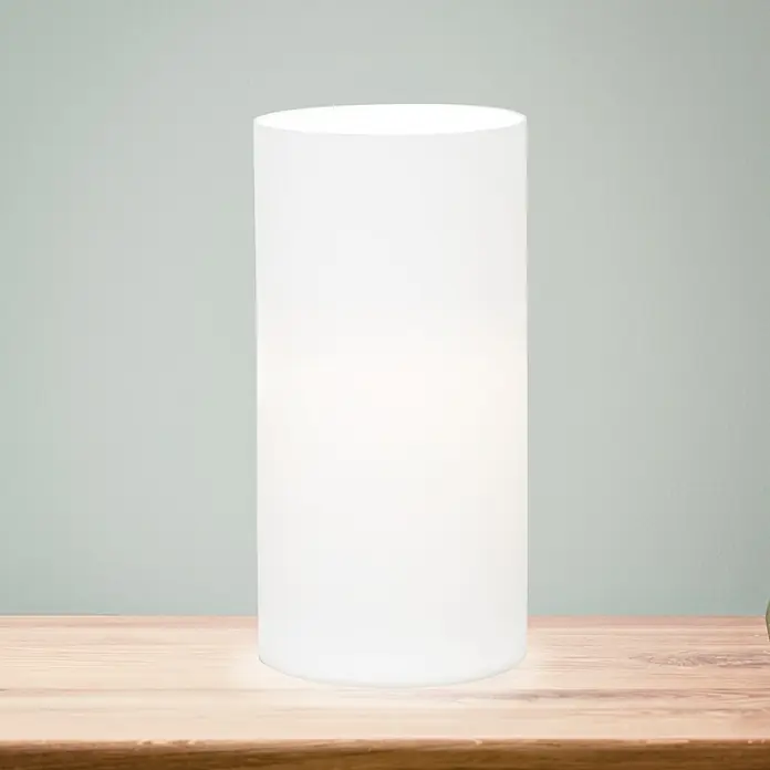 Eglo Geo Tischleuchte rund - 60 W, Ø x H: 100 mm x 20 cm, Weiß, Weiß, E14 - Nahaufnahme einer zylindrischen Tischleuchte mit einem leuchtend weißen Schirm auf einem Holztisch, die ein sanftes Licht ausstrahlt.