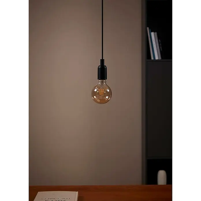 Eglo LED-Lampe - E27, Nicht Dimmbar, Warmweiß, 330 lm, 4 W, G95 - Nahaufnahme einer Hängelampe mit schwarzer Fassung und einer bernsteinfarbenen Edison-Glühbirne, die ein warmes Licht ausstrahlt.