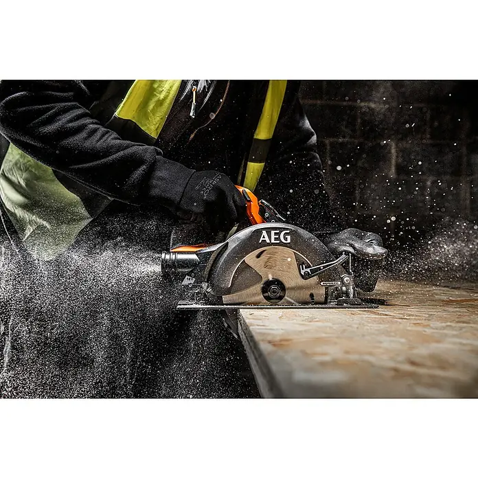 AEG Pro 18V Akku-Handkreissäge BKS 18BL2 - 18 V, Ohne Akku, 0 U/min - 5.400 U/min - Person schneidet mit einer orange-schwarzen AEG Kreissäge ein Holzbrett, wobei Sägespäne aufwirbeln.