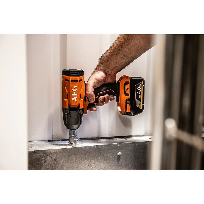AEG Pro 18V Akku-Schlagschrauber BSS 18C12ZC - 18 V, Ohne Akku, 439 Nm - Person verwendet orange-schwarzen AEG 18V Akku-Schlagschrauber zum Festziehen einer Mutter an Metallfläche.