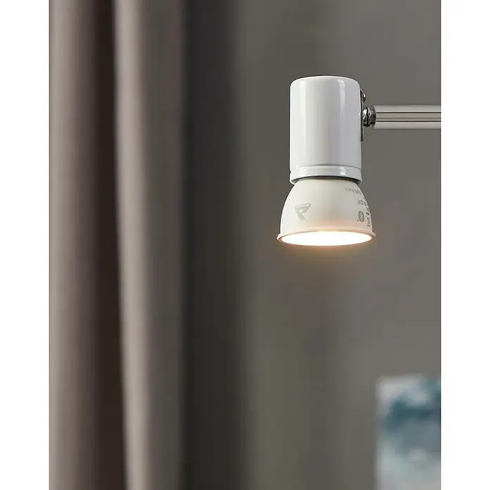 Eglo connect.z Smart-LED-Lampe Zigbee RGB/CCT - GU10, Dimmbarkeit: Dimmbar, RGBW, 345 lm, 4,9 W - Nahaufnahme einer weißen LED-Spot-Lampe an einer Metallschiene, die Licht in einem Raum mit Vorhängen spendet.