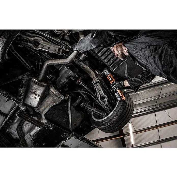 AEG Pro 18V Akku-Schlagschrauber BSS 18SRA12BL - ½″ Außenvierkant, 18 V, Ohne Akku, 320 Nm - Ein Mechaniker verwendet ein orange-schwarzes AEG Elektrowerkzeug zur Reparatur der Unterseite eines Autos.
