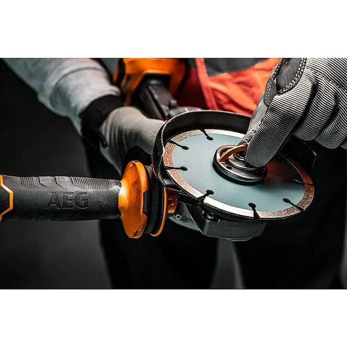 AEG Pro 18V Akku-Winkelschleifer BEWS 18-125BLPX2 - 18 V, Ohne Akku, Durchmesser Scheibe: 125 mm - Nahaufnahme einer Person in Arbeitshandschuhen, die die Diamantscheibe eines orange-schwarzen AEG Winkelschleifers einstellt.