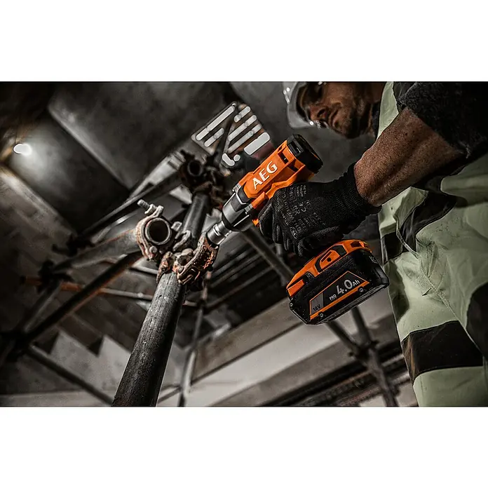 AEG Pro 18V Akku-Schlagschrauber BSS 18C12ZC - 18 V, Ohne Akku, 439 Nm - Arbeiter benutzt orange-schwarzen AEG Akku-Schlagschrauber mit 4.0Ah 18V Akku an einem Gerüst.