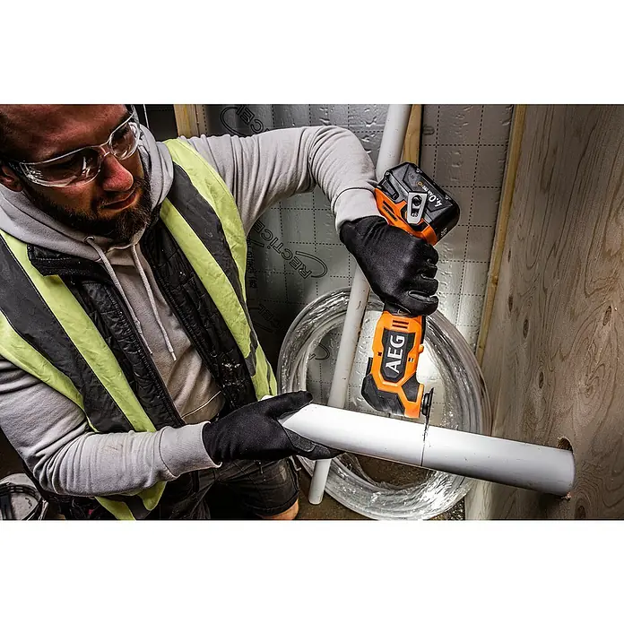 AEG Pro 18V Akku-Multifunktionswerkzeug BMT 18BL - 18 V, Ohne Akku, Leerlaufschwingzahl: 20.000 /min - Orange-schwarzes AEG Multifunktionswerkzeug schneidet ein weißes PVC-Rohr.