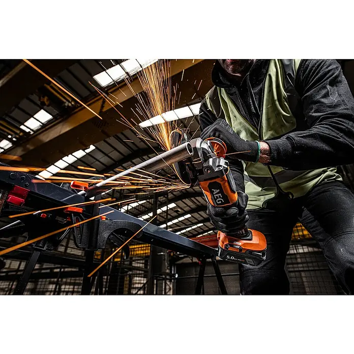AEG Pro 18V Akku-Winkelschleifer BEWS 18-125BLPX2 - 18 V, Ohne Akku, Durchmesser Scheibe: 125 mm - Person in Schutzkleidung nutzt orange-schwarzen AEG Winkelschleifer zum Schneiden eines Metallrohrs, erzeugt helle Funken.