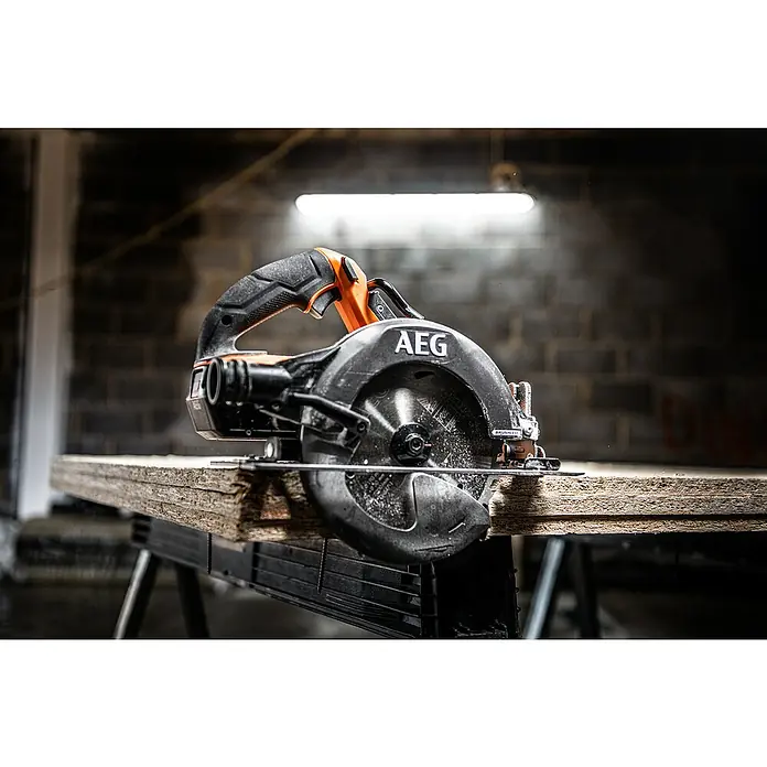 AEG Pro 18V Akku-Handkreissäge BKS 18BL2 - 18 V, Ohne Akku, 0 U/min - 5.400 U/min - Eine orange-schwarze AEG Brushless Kreissäge schneidet Holz auf einer Werkbank.