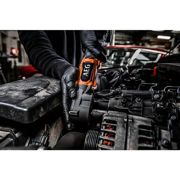 AEG Pro 18V Akku-Schlagschrauber BSS 18SRA38BL - ⅜″ Außenvierkant, 18 V, Ohne Akku, 320 Nm - Person in schwarzen Handschuhen benutzt ein orange-schwarzes AEG Elektrowerkzeug an einem Automotor.