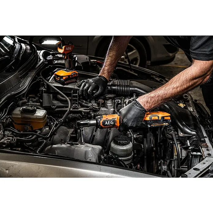 AEG Pro 18V Akku-Ratschenschrauber BSS 18R38BL - 18 V, Ohne Akku, Max. Drehmoment: 74 Nm - Mechaniker nutzt orange-schwarze AEG Akkuknarre und Leuchte im Motorraum eines Autos.