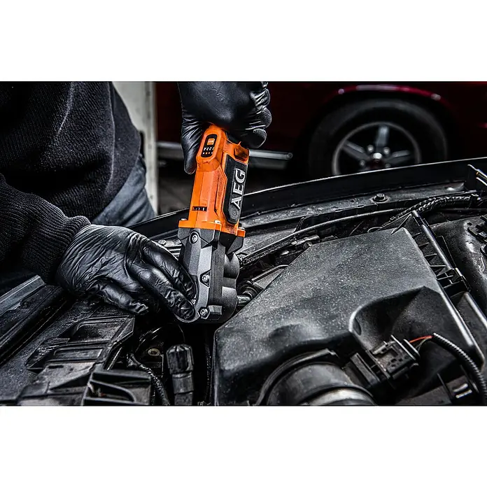 AEG Pro 18V Akku-Schlagschrauber BSS 18SRA38BL - ⅜″ Außenvierkant, 18 V, Ohne Akku, 320 Nm - Person in schwarzen Handschuhen arbeitet mit einem orange-schwarzen AEG Elektrowerkzeug am Automotor.
