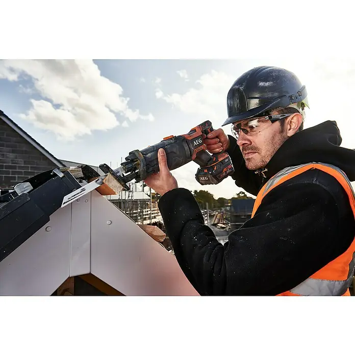 AEG Pro 18V Akku-Säbelsäge BUS 18BL2 - 18 V, Ohne Akku, Leerlaufhubzahl: 0 /min - 3.200 /min - Bauarbeiter schneidet Holz mit einer orange-schwarzen AEG 18V Säbelsäge auf einem Dach.