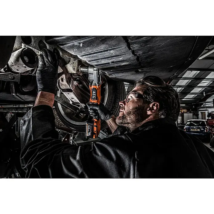 AEG Pro 18V Akku-Schlagschrauber BSS 18SRA12BL - ½″ Außenvierkant, 18 V, Ohne Akku, 320 Nm - Orange-grauer AEG Akku-Ratschenschrauber, von einem Mechaniker unter einem Auto verwendet.