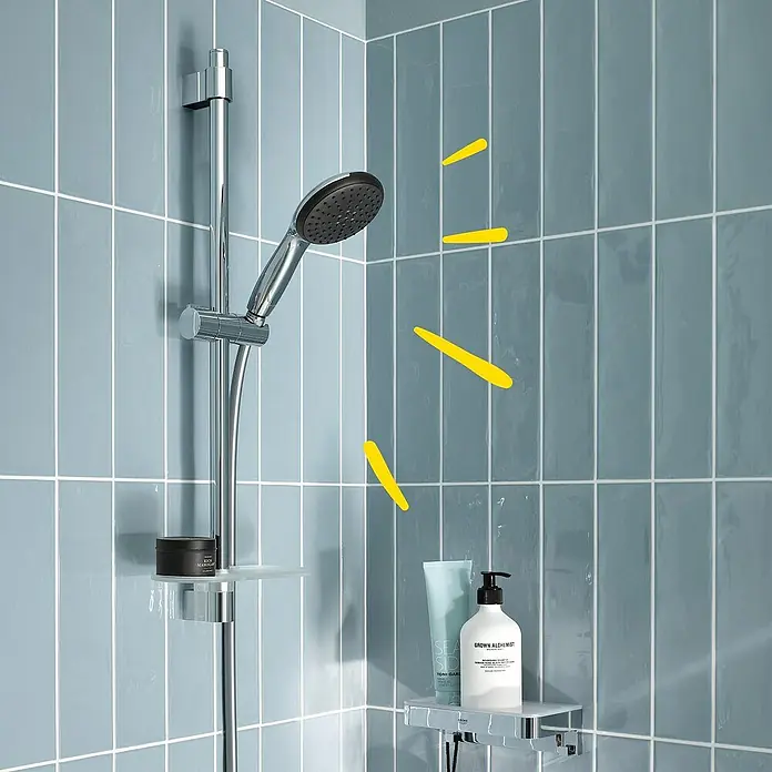 Grohe QuickFix Vitalio Start Brause-Set 110 2 - Chrom, Metall, Anzahl Strahlarten: 2 Stk. - Verchromtes Duschsystem mit Handbrause, Gleitstange und zwei Ablagen für Toilettenartikel, an blauen Fliesenwänden im Badezimmer.