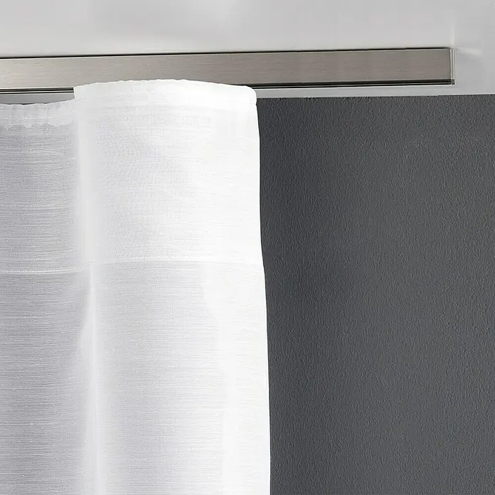 Expo Ambiente Gardinenprofil Smart Set - Anzahl Läufe: 1 Stk., Silber, 240 cm - Detailaufnahme einer weißen Gardine mit metallfarbener Gardinenstange vor einer grauen Wand. Die Vorhänge sind lichtdurchlässig und wirken elegant.