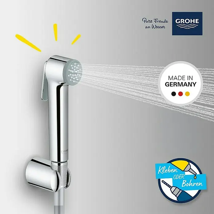 Grohe Brause-Set Vitalio Trigger Spray 30 - Chrom, Glänzend - Eine GROHE Bidetdusche in Chrom ist an einer grauen Wand montiert und sprüht Wasser. Hergestellt in Deutschland.
