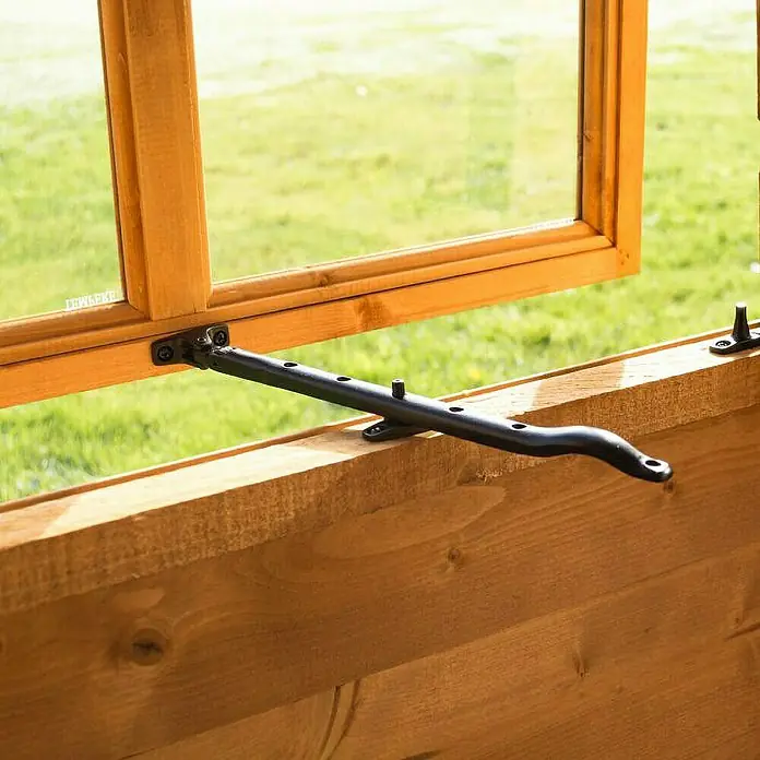 Bertilo Gartenhaus Melrose - Außenmaß inkl. Dachüberstand (B x T): 246 x 214 cm, Holz - Nahaufnahme eines Fensteröffners aus schwarzem Metall, der an einem Holzfensterrahmen befestigt ist und zum Öffnen eines Fensters dient.