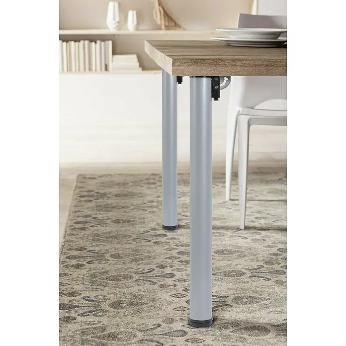 Element System Pata para muebles - Ø x Al: 5 x 70 cm, Capacidad de carga: 50 kg, Acero - Primer plano de una mesa plegable con patas plateadas y una alfombra estampada debajo.
