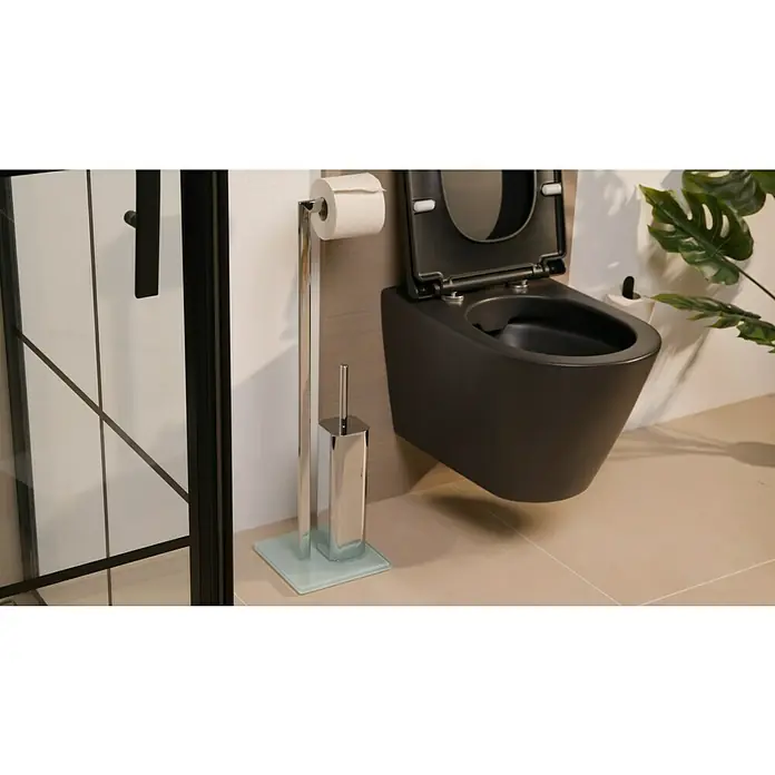 Camargue Toilettenbutler Chariz - Höhe: 72 cm, Chrom, Glänzend - Ein modernes Badezimmer mit einer schwarzen Wandtoilette, einem freistehenden Toilettenpapierhalter und einer Zimmerpflanze.