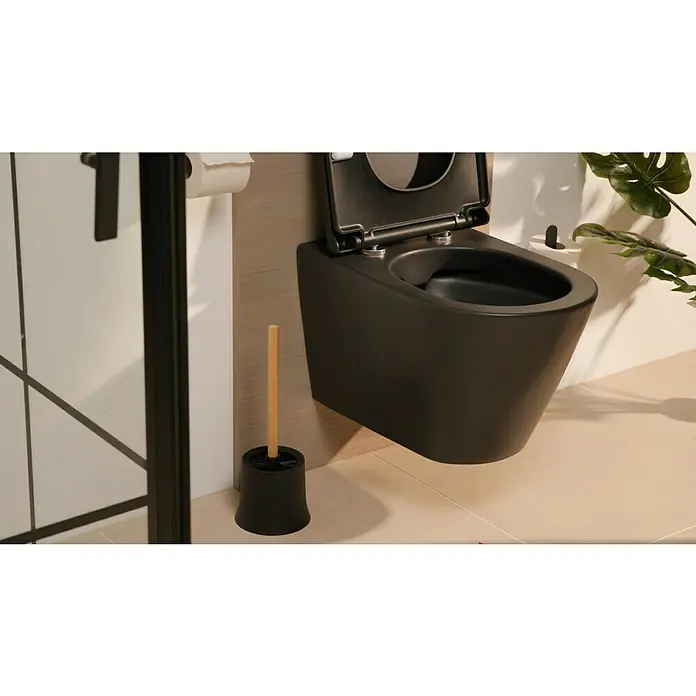 Wenko Bambusa WC-BürstengarniturBambus, Schwarz/Bambus - Detailaufnahme einer modernen, wandhängenden Toilette in Schwarz mit offenem Deckel, neben einer Toilettenbürste.