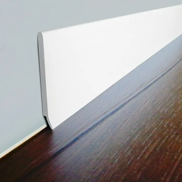 LOGOCLIC Abdeckleiste - 250 cm x 40 mm x 3,2 mm, Weiß - Nahaufnahme einer weißen Fußleiste, die den Übergang zwischen Wand und dunklem Holzboden elegant verdeckt.