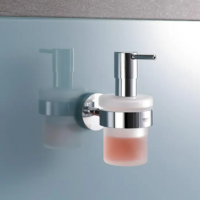 Grohe Essentials Seifenspender - Mit Halterung, Chrom, Glänzend - Nahaufnahme eines Wandseifenspenders von Grohe mit satiniertem Glasbehälter und Chromhalterung.