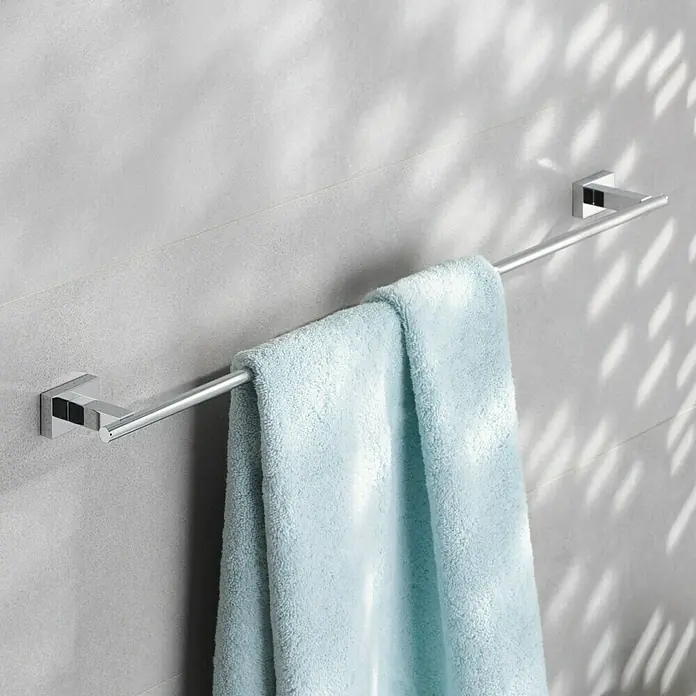 Grohe Essentials Cube Badetuchhalter - Breite: 55,8 cm, Chrom, Glänzend - Ein moderner Handtuchhalter aus Chrom mit einem hellblauen Handtuch hängt an einer grauen Wand mit Lichteffekten.