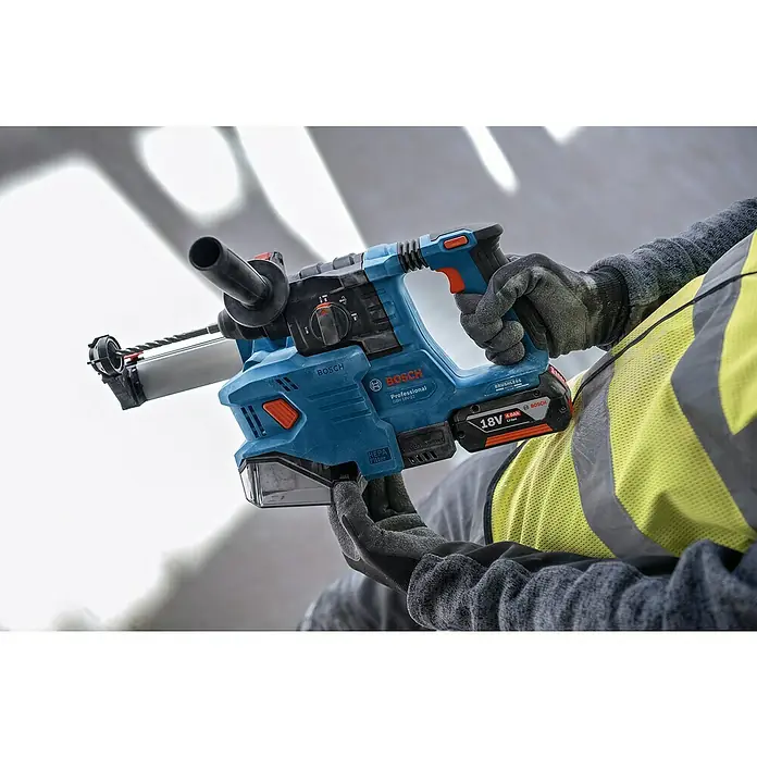 Bosch Professional AMPShare 18V Akku-Bohrhammer PRO GBH 18V-22 - 18 V, 2 Akkus, 4 Ah, 1,9 J - Nahaufnahme eines Bosch Professional Akku-Bohrhammers GBR 18V-22 mit Bohrstaubabsaugung und einem Arbeiter mit Arbeitshandschuhen.