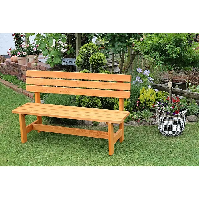 Promadino Gartenbank Summer - B x T x H: 150 x 51 x 90 cm, Nadelholz, Honigbraun - Gartenbank aus Holz auf Rasen mit Blumen und Pflanzen im Hintergrund. Die Bank lädt zum Verweilen im Grünen ein.