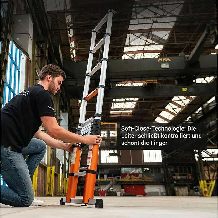Batavia Teleskopleiter - Anzahl Tritte: 12 Stk., Arbeitshöhe: 460 cm, Belastbarkeit: 150 kg, Aluminium - Mann klappt eine orangefarbene Teleskopleiter mit Soft-Close-Technologie in einer Industriehalle zusammen.