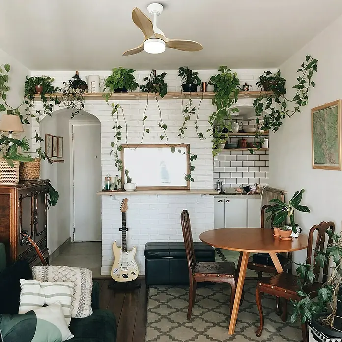 Cristal Record Ventilador de techo Beta - Blanco/Madera, 92 cm, 27 W, Blanco cálido - Salón con ventilador de techo, plantas y guitarra. Decoración acogedora con un ventilador luminoso como foco entre abundante vegetación.