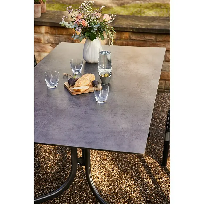 Siena Garden Urban Lights Gartenmöbel-Set Square Stuhl/Sola Tisch - 5 -tlg., Polypropylen, Olive/Anthrazit - Nahaufnahme eines Gartentisches mit Speisen und Getränken, der eine einladende Atmosphäre für Mahlzeiten im Freien schafft.
