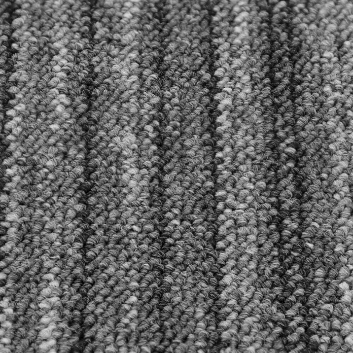 Teppichfliese Vienna - Schlinge, 100 % Polypropylen, Grau Gestreift - Nahaufnahme eines grauen Teppichs mit unterschiedlichen Texturen, der ein dichtes und einladendes Gefühl vermittelt.