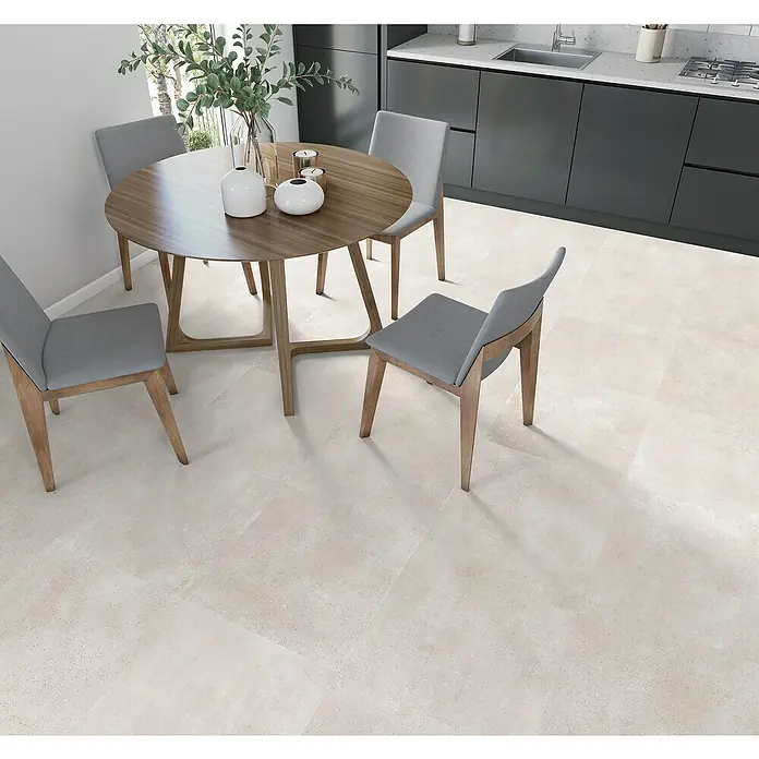 Halcón Pavimento porcelánico Amira - 60,5 x 60,5 cm, Bone, Mate - Una mesa de comedor con cuatro sillas sobre un suelo de baldosas claras en una cocina moderna. El diseño sencillo complementa la cocina.