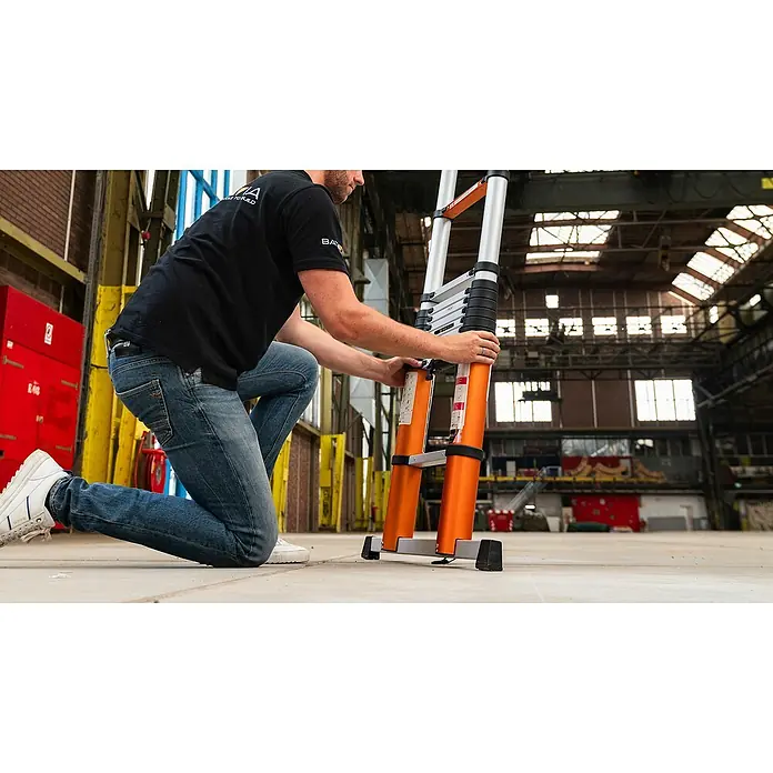 Batavia Teleskopleiter - Anzahl Tritte: 14 Stk., Arbeitshöhe: 515 cm, Belastbarkeit: 150 kg, Aluminium - Mann, der eine ausziehbare Aluminium-Teleskopleiter in einer Lagerhalle aufstellt, die sich ideal für verschiedene Aufgaben eignet.
